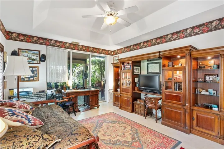 Office featuring ceiling fan, a raised ceiling, and light tile floors