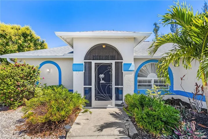 Doorway to property with roof with shingles and stucco siding