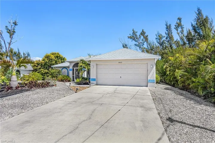 View of front of home with concrete driveway, an attached garage, and stucco siding