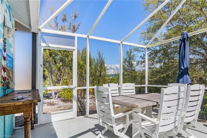 Pool cage featuring outdoor dining area, plenty of natural light, and a patio area