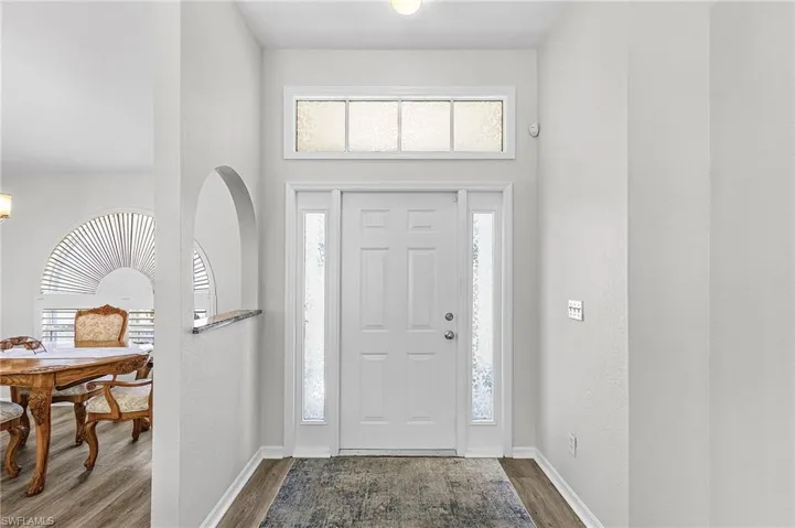 Foyer entrance with wood finished floors and baseboards