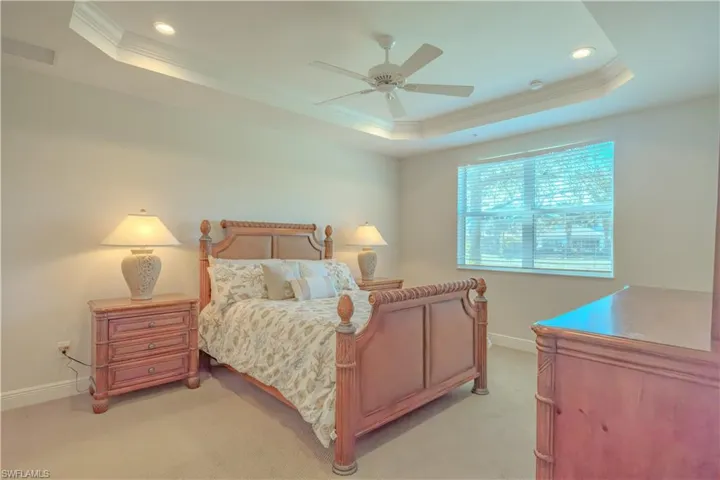 Bedroom featuring crown molding, ceiling fan, light carpet, recessed lighting, and a raised ceiling