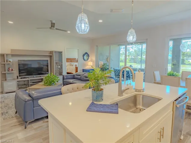 Kitchen featuring white cabinets, pendant lighting, light wood-style flooring, open floor plan, and dishwasher