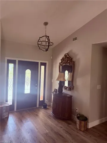 Foyer entrance with a chandelier and wood finished floors