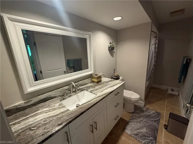 Full bathroom featuring vanity, tile patterned floors, and shower / bathtub combination with curtain