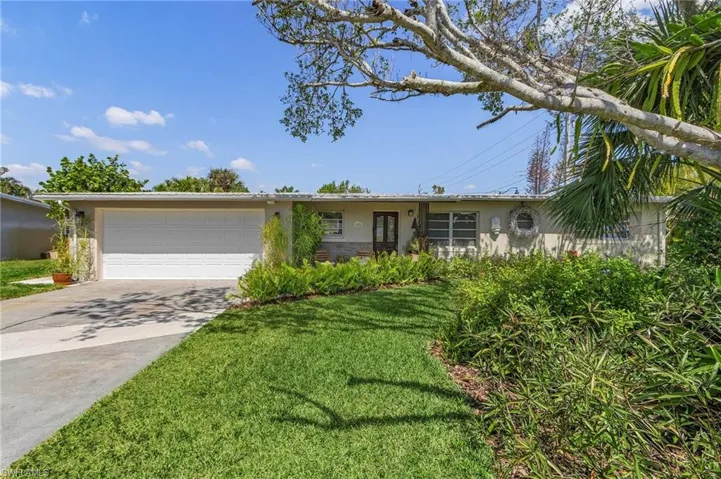 Ranch-style house featuring stucco siding, a front lawn, concrete driveway, and a garage