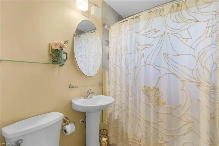 Bathroom with toilet and a shower with curtain