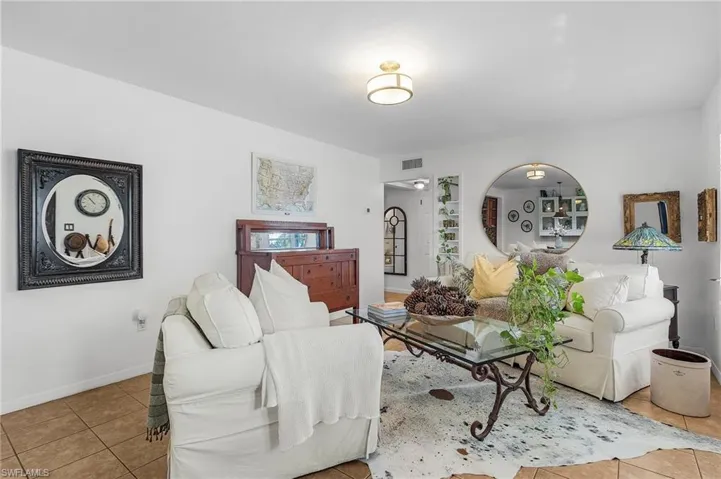 Living area with visible vents, baseboards, and tile patterned flooring