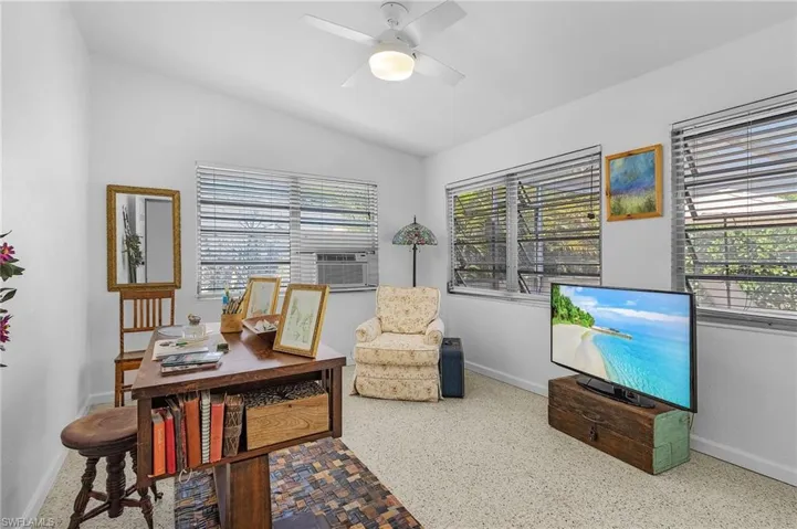Office area featuring lofted ceiling, cooling unit, baseboards, and ceiling fan