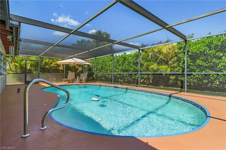 Outdoor pool with glass enclosure and a patio