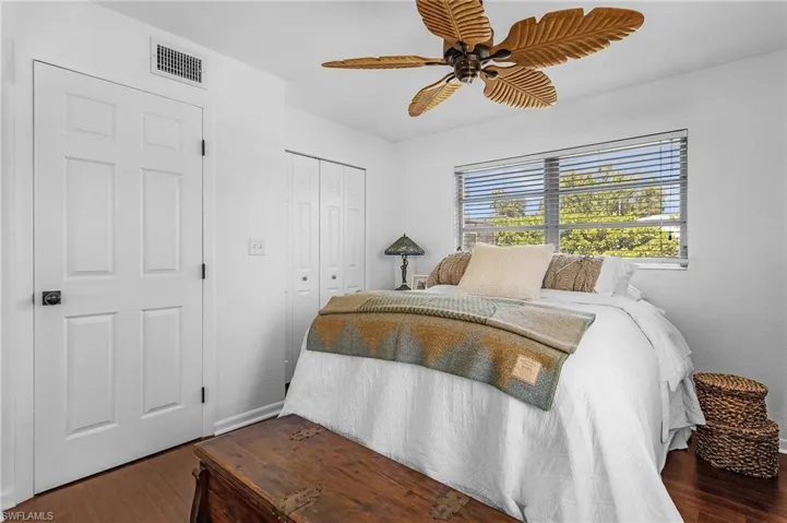 Bedroom featuring a ceiling fan, wood finished floors, visible vents, and a closet
