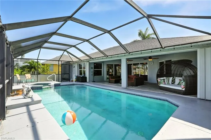 View of swimming pool with a lanai, outdoor lounge area, a patio area, and a pool with connected hot tub