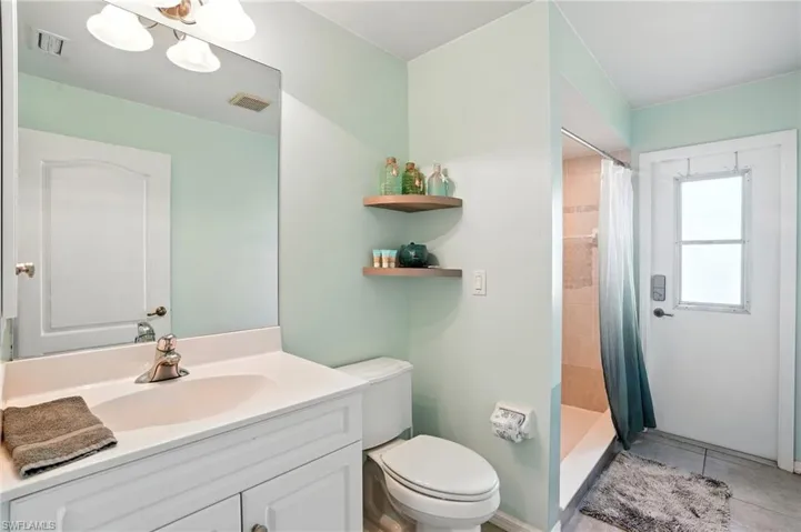 Full bathroom with vanity, tile patterned flooring, and a door out to pool area