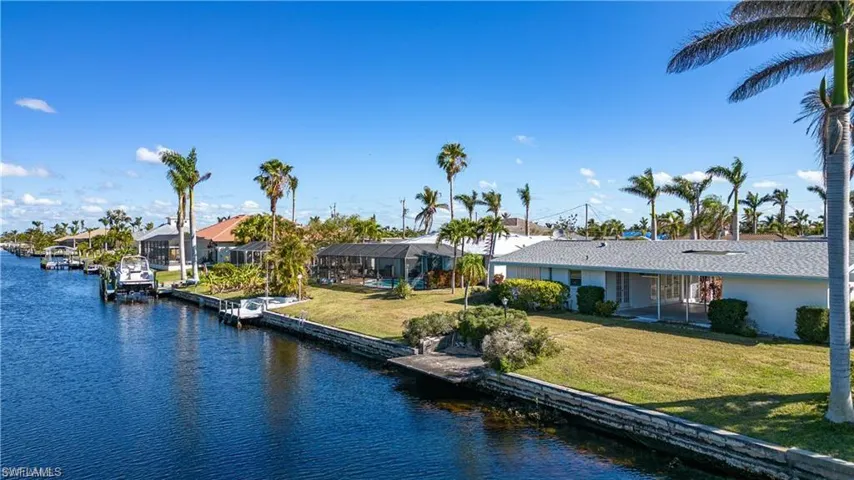 Dock featuring a water view, a lawn, and a residential view