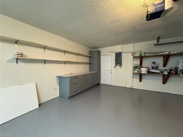 Garage with electric panel and a garage door opener