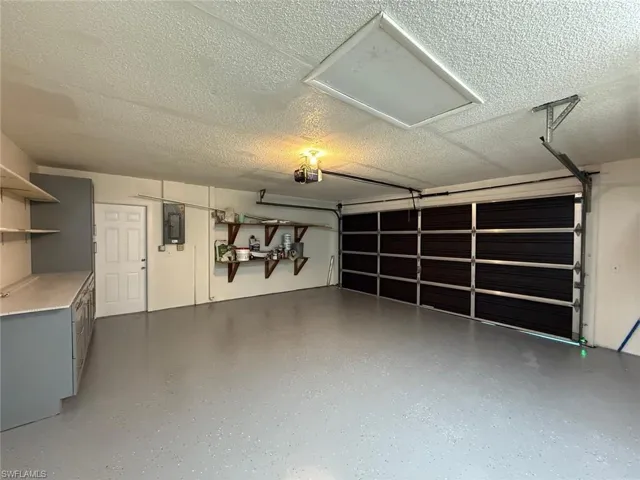 Garage featuring electric panel and a garage door opener