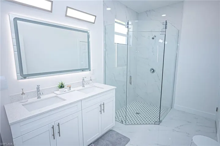 Bathroom featuring a sink, a marble finish shower, and marble finish floor