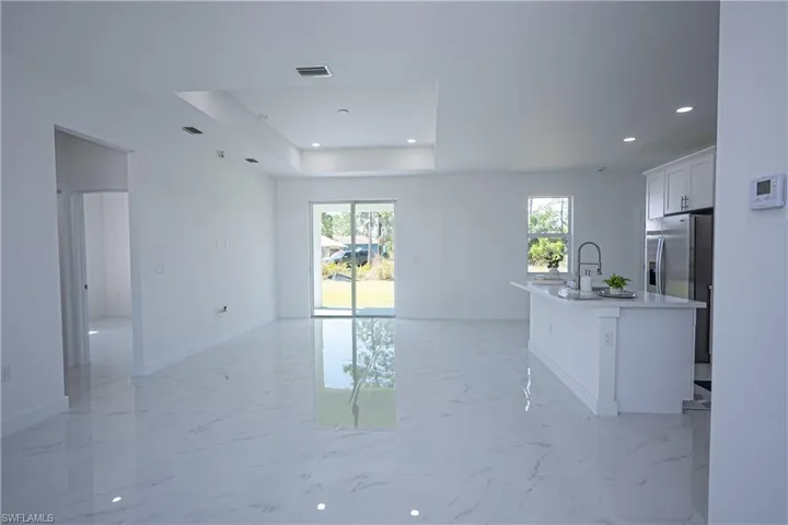 Unfurnished living room with baseboards, visible vents, recessed lighting, and marble finish floor