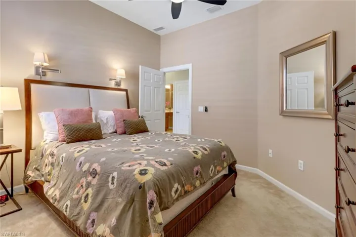 Bedroom with ceiling fan and light colored carpet