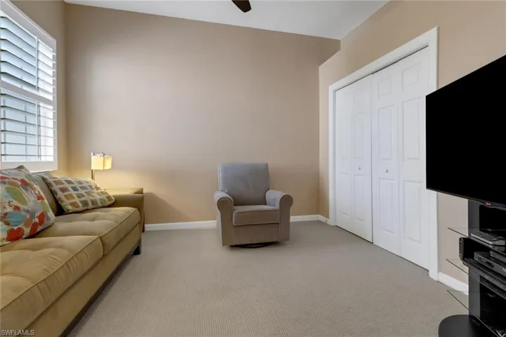 Carpeted living room with ceiling fan