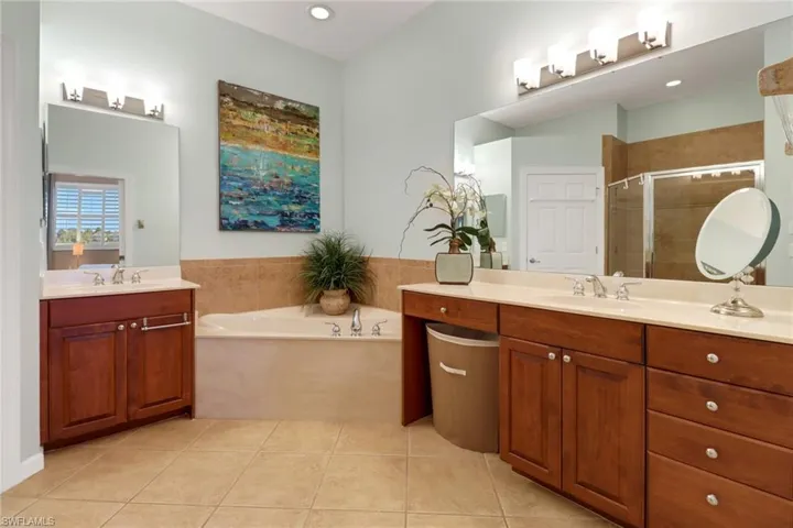 Bathroom featuring independent shower and bath, tile patterned flooring, and vanity