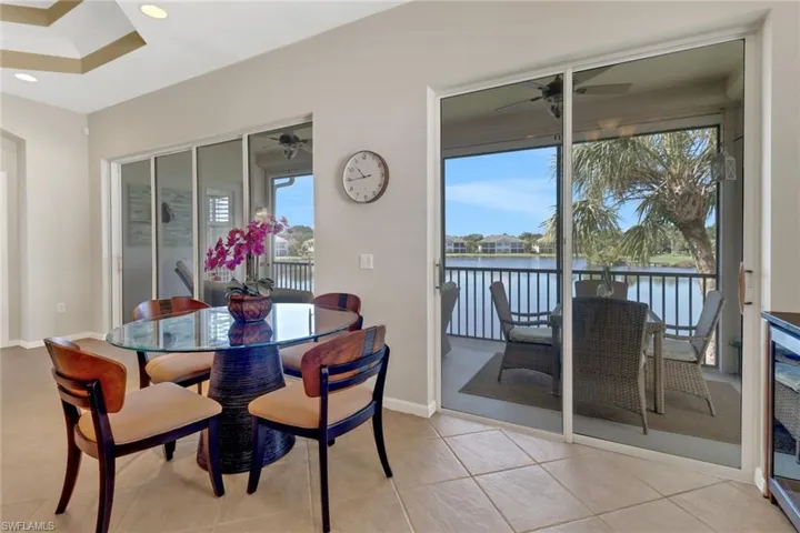 Tiled dining room with a water view and ceiling fan