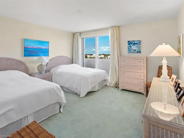 Guest bedroom has two queen beds and sunny easterly balcony with sliding glass door