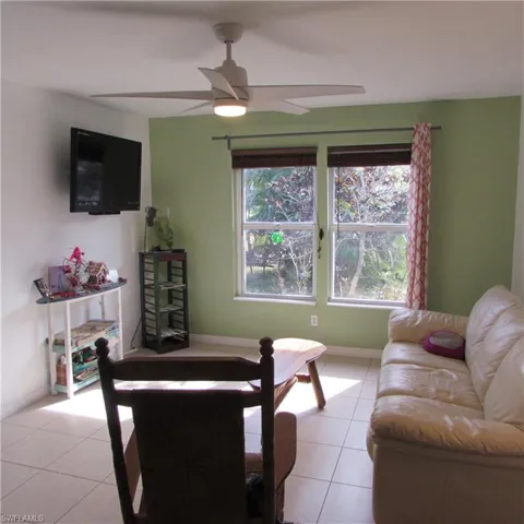 Tiled living room featuring ceiling fan