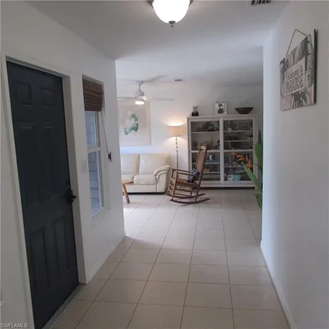 Hallway featuring light tile patterned floors