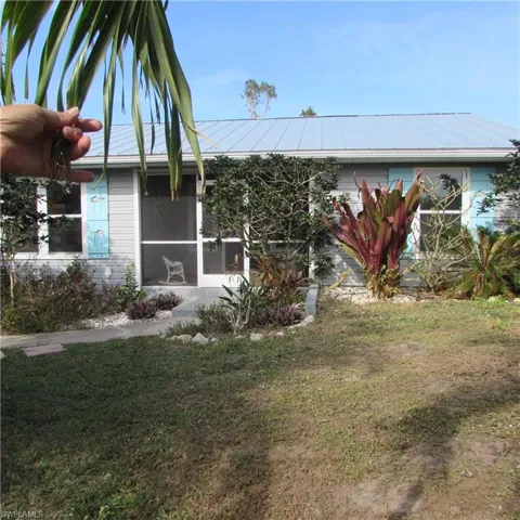 View of property exterior with a sunroom and a yard