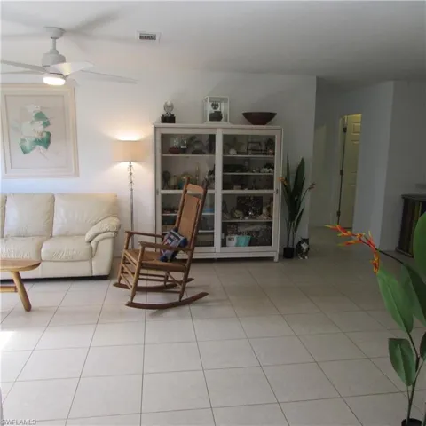 Living room with ceiling fan and light tile patterned floors