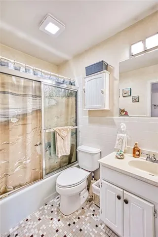 full bath with enclosed tub/shower combo, tile flooring