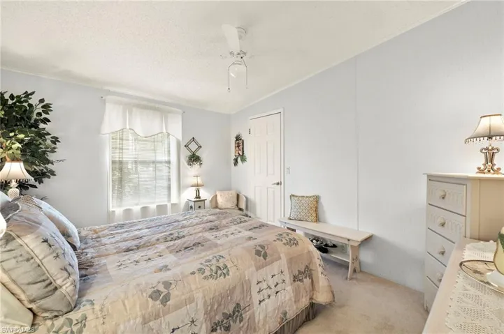 Bedroom featuring crown molding, vaulted ceiling, ceiling fan, a textured ceiling, and light colored carpet  FURNITURE STAYS