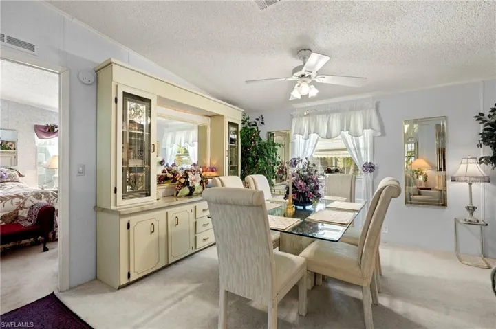 Carpeted dining area with ceiling fan, crown molding, and a textured ceiling