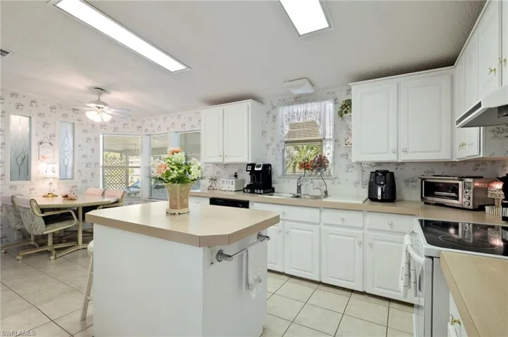 Kitchen with sink, white cabinets, and a healthy amount of sunlight