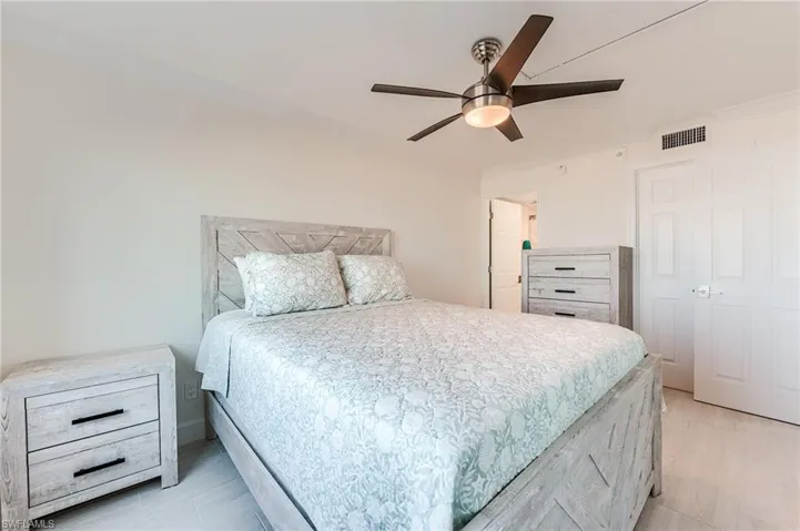 Bedroom featuring ceiling fan, ornamental molding, and light wood-style flooring
