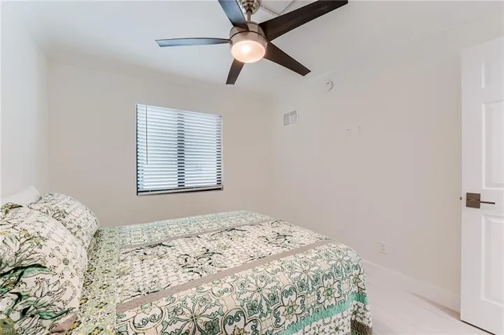 Bedroom featuring ornamental molding, a ceiling fan, and light wood-style flooring