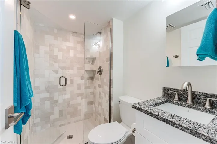 Bathroom featuring recessed lighting, vanity, and a stall shower