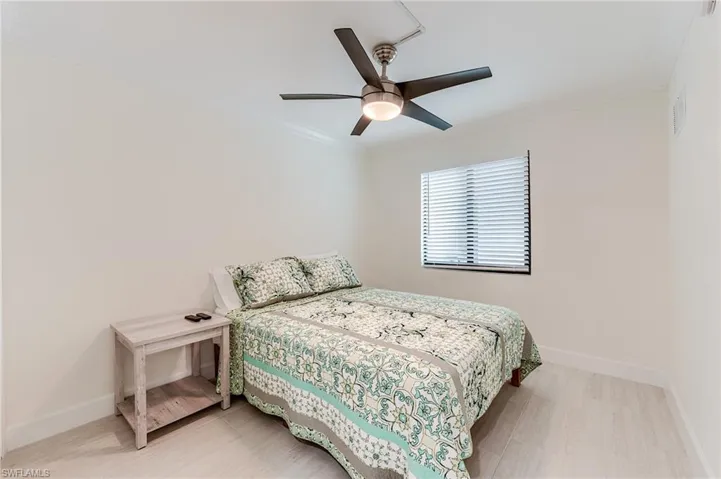 Bedroom featuring ornamental molding, a ceiling fan, and light wood-type flooring