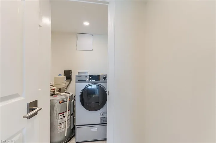 Laundry area featuring washer / dryer, water heater, and recessed lighting