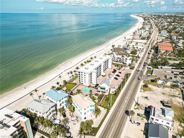 Drone / aerial view of unending shoreline and apartment complex / building