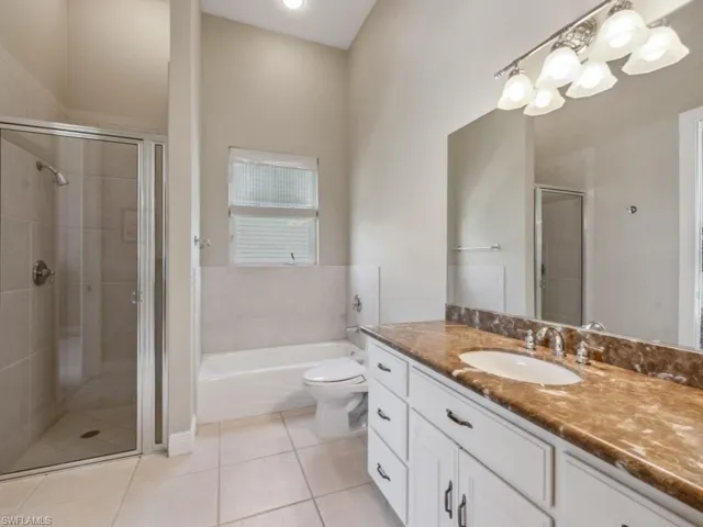 Bathroom with vanity, a stall shower, tile patterned flooring, a bath, and toilet