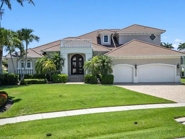 Mediterranean / spanish home with a garage, decorative driveway, a front yard, and a tile roof