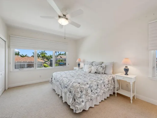 Bedroom featuring baseboards, light carpet, and a ceiling fan