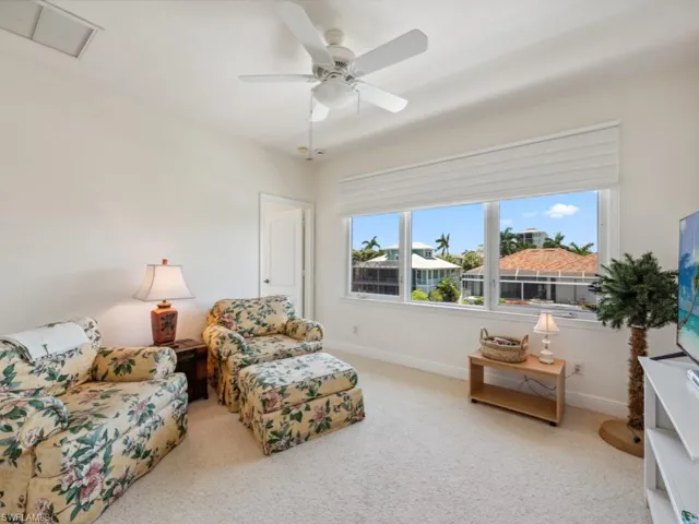 Carpeted living room featuring baseboards and ceiling fan