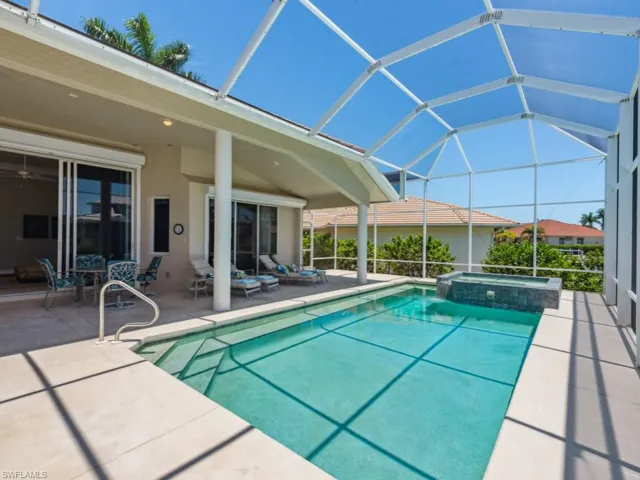View of pool featuring a patio area, a pool with connected hot tub, a lanai, and an outdoor hangout area