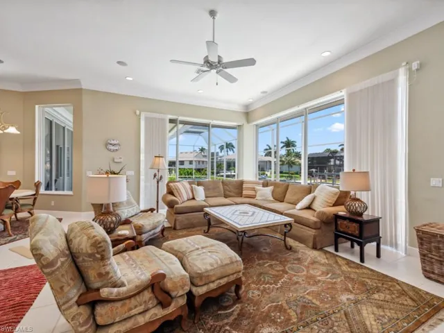 Living area featuring light tile patterned floors, healthy amount of natural light, a ceiling fan, ornamental molding, and recessed lighting