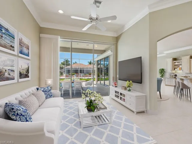Living area featuring ceiling fan, arched walkways, ornamental molding, light tile patterned floors, and recessed lighting