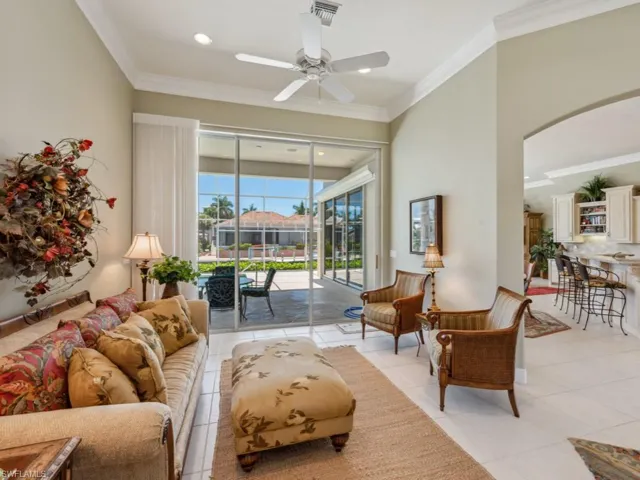 Living area with a ceiling fan, arched walkways, ornamental molding, light tile patterned floors, and recessed lighting