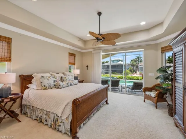 Bedroom with light colored carpet, access to outside, a raised ceiling, a ceiling fan, and recessed lighting